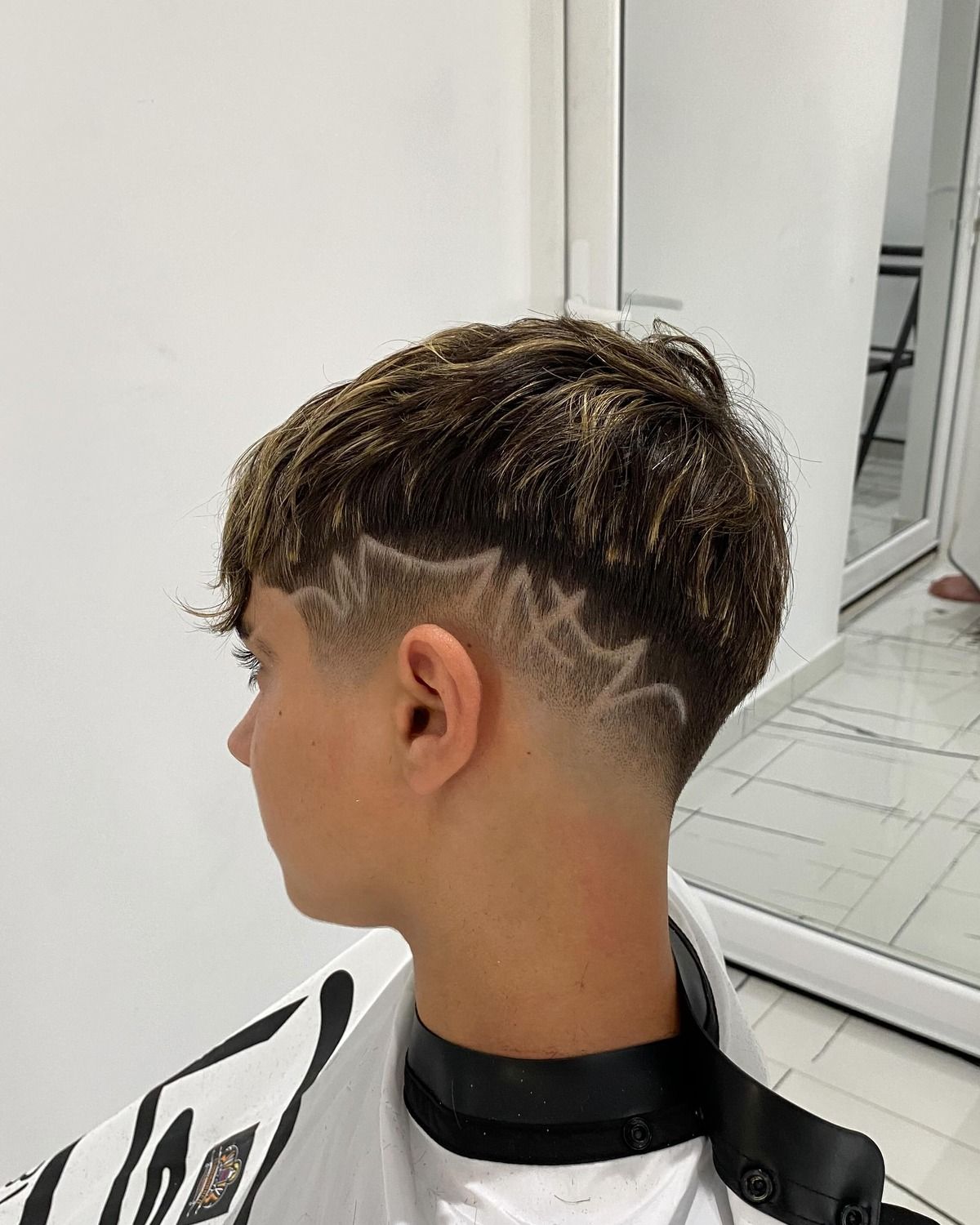 Back view of a taper fade with a line design shaved in