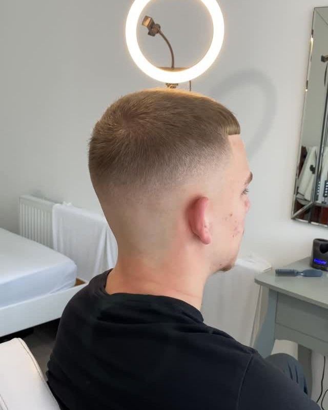 Back view of a high skin fade with a blurry blend, under the ring light
